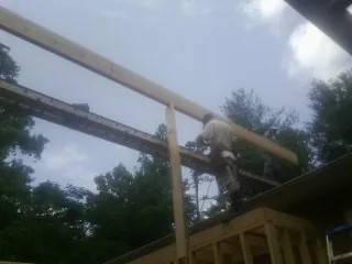 Carpenter setting a ridge beam over a new addition frame — Ice Dam Removal by Roofing Brothers in Branch