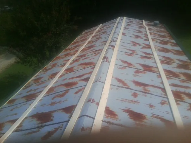 Rusted metal roof panels with new wood purlins before replacement — Storm Damage Roof Repair in Branch by Roofing Brothers