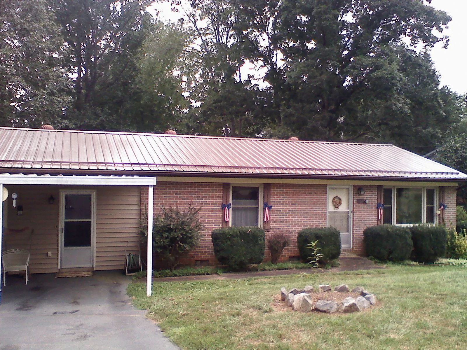 Bronze metal roof and carport on a brick ranch home — Roof Repair work by our crew in Branch